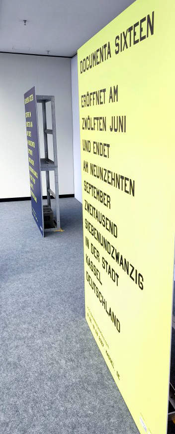 Großformatige gelbe Hartschaumplatte mit dunkler Typografie zur Ankündigung der documenta 16