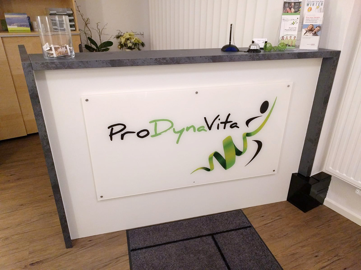 Rückseitig bedruckte Acrylglasplatte mit Logo an der Front eines Empfangstresens