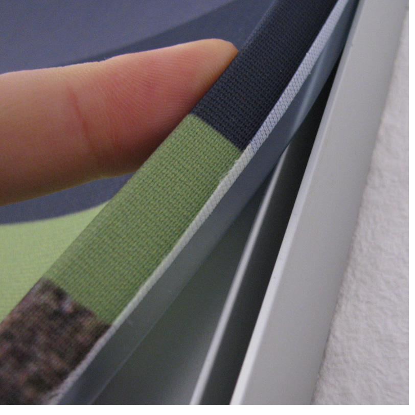 Nahaufnahme einer Rahmenkante mit faltenfrei eingespanntem bedrucktem Textil